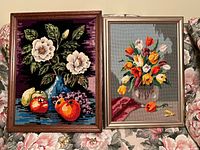 Both framed needlepoint artworks side by side showing designs, frames, colours and scale