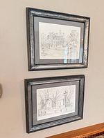 Two framed architectural prints hanging on wall