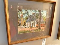 Framed print with cottage scene, mat and wood frame visible