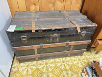 Full view of antique wood steamer trunk with metal hardware and wood slats