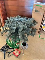 Disassembled tree sections, metal stand, tree skirt and box