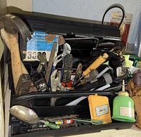 Open black plastic toolbox showing assorted hand tools and accessories
