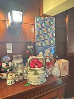 Shelf with various snowman decorations including boxed items, jars, figurines and acrylic snowmen