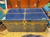 Full view of trunk front showing blue finish, brass hardware, latches, lock