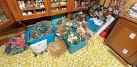 Overall lot view in front of cabinet showing multiple storage totes filled with wreaths, garlands and florals