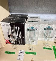 Boxed Ornella and Contessa crystal stemware with loose examples; shelf labels showing quantities