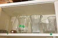 Shelf view showing all clear glass vases and flower frog