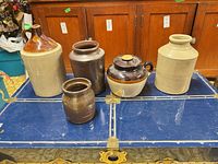 Group of five stoneware vessels on blue trunk