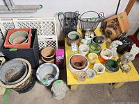 Overall lot showing assorted planters, pots and ornaments on and beside yellow table