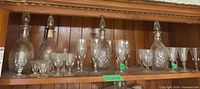 Shelf view with three decanters and mixed stemware
