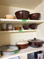 Cabinet view showing majority of stoneware and ceramic pieces