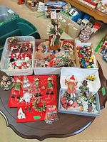 Overview of entire lot on table showing tubs and boxes of assorted ornaments and decorations