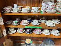 Cabinet shelves showing multiple teacup and saucer sets