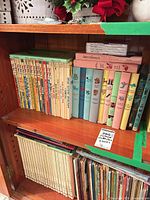 Full shelf view showing Dr. Seuss row, pastel books, childcraft volumes and Disney set