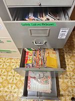 Two file drawers open showing stacks of magazines and cookbooks