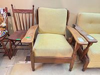 Front view of wood armchair showing upholstery, arms, and slat back