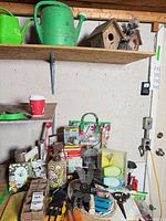 Shelf with watering cans, birdhouses and assorted garden supplies