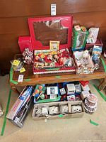 overall view of assorted boxed ornaments, elves, train pieces and tins on two-tier table