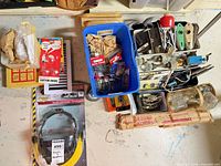 Overview of bins containing mixed hardware, glass knobs, hooks, fasteners and bottles