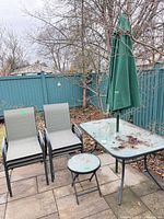 Full view of patio set showing dining table, umbrella, four chairs, side table