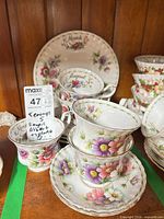 Stacked teacups, saucers and two small plates showing March and August patterns