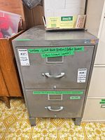 Front view of two-drawer filing cabinet showing overall form, handles and label frames