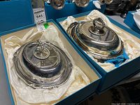 Two boxed silver-plated covered dishes with underplates