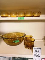 Full set on shelf: punch bowl, ladle, five cups on upper shelf, creamer, sugar and tray
