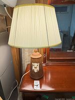 Lamp on nightstand showing full lamp with shade and base