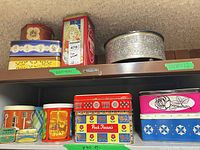 Shelf with multiple tins showing brands and designs