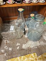Group shot of all four glass containers: car jar, cow milk bottle, pig jar and Bicentennial jug
