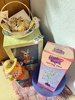 Group shot showing boxed Spring Bunny, boxed Spring Tree, plush bunny, wicker basket with cards and chick, loose ornaments