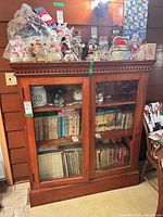 Front view of wood glass-front bookcase with contents for scale