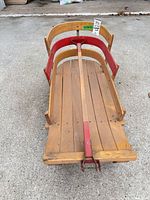Top view of wooden sled showing slatted deck, side rails, metal runners