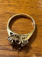 Top view of gold ring showing empty center setting and two side diamonds