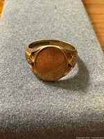 Top view of oval signet ring showing unengraved face and yellow gold color