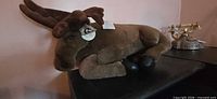 Side view of plush moose lying on surface showing full body