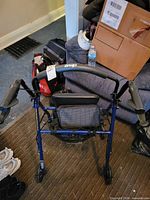 Front view of blue Drive rollator walker with seat and brakes