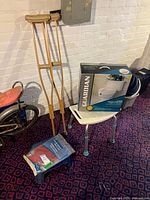 Group shot showing crutches, boxed toilet seat, shower bench, hot water bottle on blue stool