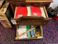 Drawer with three Hilroy 200-sheet paper packs, pens, ruler, notebooks, envelopes
