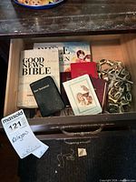 Drawer containing various bibles and crucifix