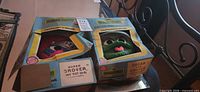 Two boxed Sesame Street costume sets, masks visible through windows