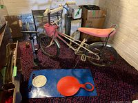 Full view of bicycle, pump and Crazy Carpet on floor