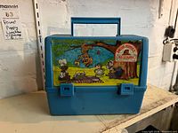 Front view of blue lunchbox showing decal and handle
