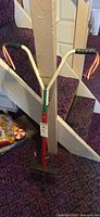 Full view of pogo stick leaning against stair post
