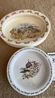 Stack of Bunnykins oval bowl atop Peter Rabbit round bowl shows size, rim patterns and illustrations