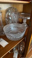 Group of clear cut crystal and glass pieces in cabinet