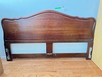 Front view of full headboard showing arched top, wood grain and mounting brackets