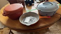 All three cookware pieces on table for scale and color reference