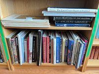 Two shelves of oversized art and reference books, vertical and horizontal stacks visible